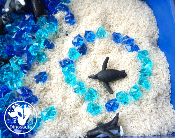 Penguin Rice Sensory Bin - with penguins, blue acrylic rocks and rice for a fun polar animal sensory bin that kids can play in. - 3Dinosaurs.com