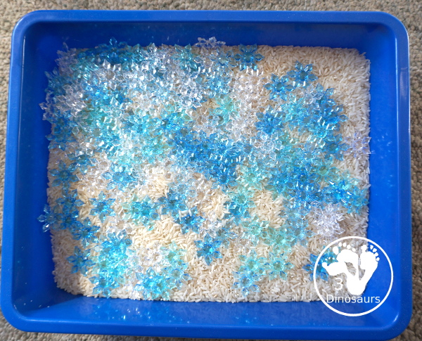 Snowflake Sensory Bin with Rice Filler - a simple sensory bin with rice for the filler and three colors of acrylic snowflakes in the sensory bin. Only a minute to set up this sensory bin. - 3Dinosaurs.com