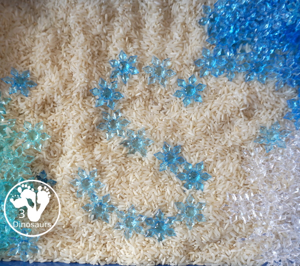 Snowflake Sensory Bin with Rice Filler - a simple sensory bin with rice for the filler and three colors of acrylic snowflakes in the sensory bin. Only a minute to set up this sensory bin. - 3Dinosaurs.com