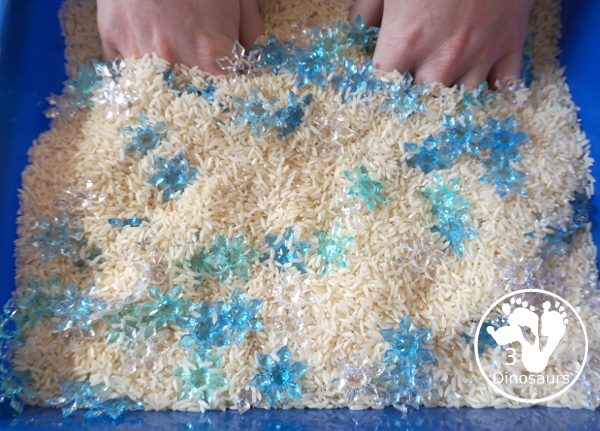 Snowflake Sensory Bin with Rice Filler - a simple sensory bin with rice for the filler and three colors of acrylic snowflakes in the sensory bin. Only a minute to set up this sensory bin. - 3Dinosaurs.com