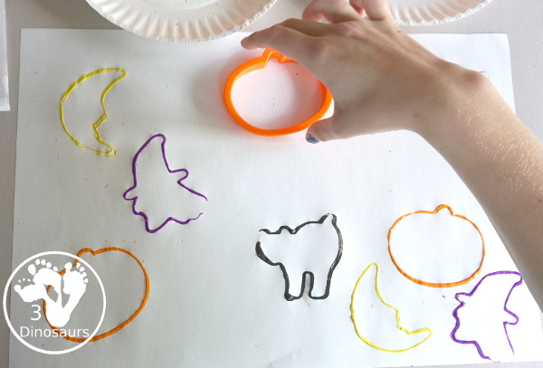 Halloween Stamping With Cookie Cutters - painting with cookie cutters using them to stamp paint with the cookie cutters on a piece of paper. A great tot, preschool and prek painting activity - 3Dinosaurs.com