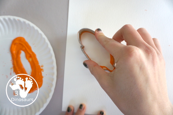 Turkey Feather Scrap Painting for Kids - a fun turkey craft made with a cookie cutter feather and construction paper. A fun painting idea with feathers for a Thanksgiving craft for kids in preschool, prek, and kindergarten. 3Dinosaurs.com