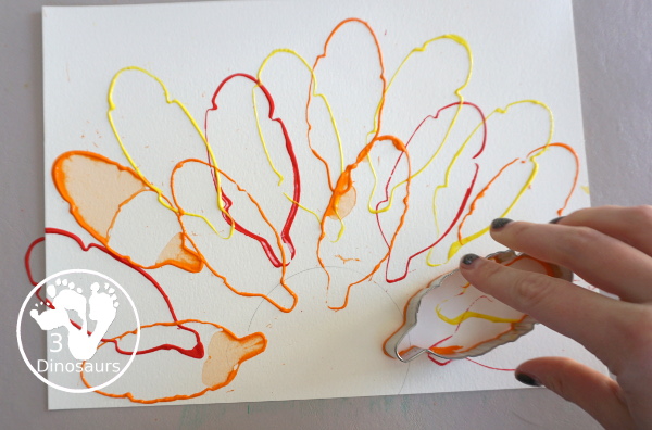 Turkey Feather Stamp Painting for Kids - a fun turkey craft made with a cookie cutter feather and construction paper. A fun idea for a Thanksgiving craft for kids in preschool, prek, and kindergarten. 3Dinosaurs.com