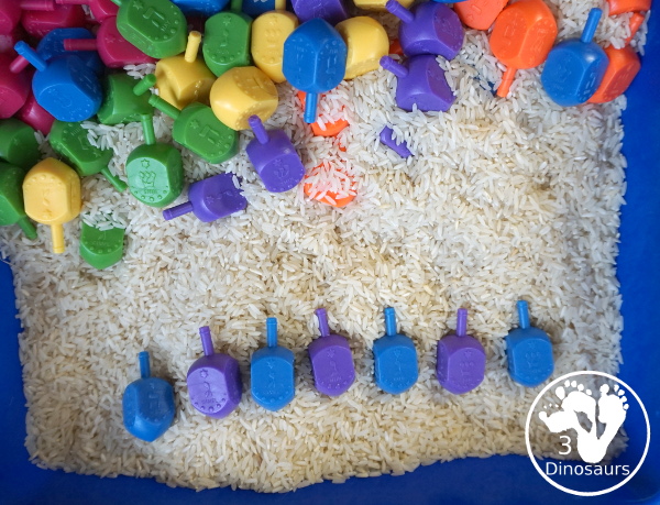 Dreidel Sensory Bin with Rice for Hanukkah - A simple Hanukkah sensory bin with dreidels and rice for the sensory bin - 3Dinosaurs.com