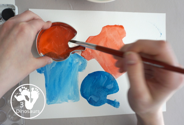 Football Cookie Cutter Watercolor Painting - a fun painting that kids can do with a football theme. A great way to do a fun watercolor painting is by different football team colors. - 3Dinosaurs.com