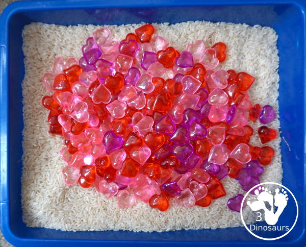 Heart Rice Sensory Bin For Kids - acrylic hearts in a rice sensory bin that you can use with kids during Valentines or a heart shape theme. - 3Dinosaurs.com