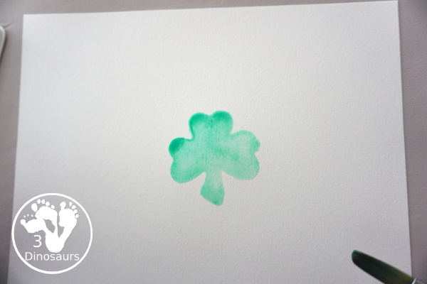 Clover Watercolor Painting for kids - You use watercolor paints, watercolor paper, and clover cookie cutters to make a fun Saint Patrick's Day watercolor painting - 3Dinosaurs.com