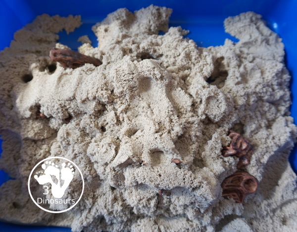 Dinosaur and Kinetic Sand Sensory Bin - a simple sensory bin put together to play with dinosaur bones and kinetic sand. Super simple to set up and use for sensory play.- 3Dinosaurs.com