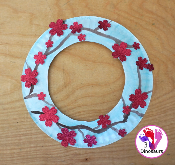 Cherry Blossom Wreath is a great spring wreath that kids can make with a paper plate for the base and watercolor and cherry blossom punches for the flowers. The Cherry Blossom Wreath is perfect for spring. - 3Dinosaurs.com