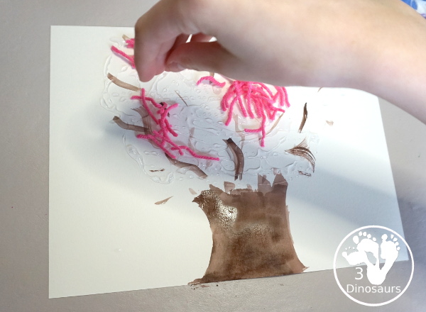 Spring Yarn Tree Craft For Kids - a fun craft made with watercolor for the tree trunk and yarn for the spring blossoms. Super easy to make and great for different ages. - 3Dinosaurs.com