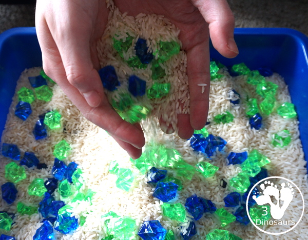 Blue and Green Sensory Bin For Earth Day - pouring the rice and rock back into the sensory bin - 3Dinosaurs.com