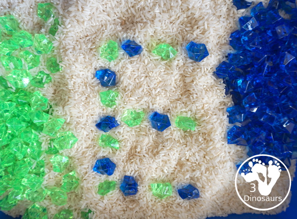 Blue and Green Sensory Bin For Earth Day - making letters with the rocks - 3Dinosaurs.com