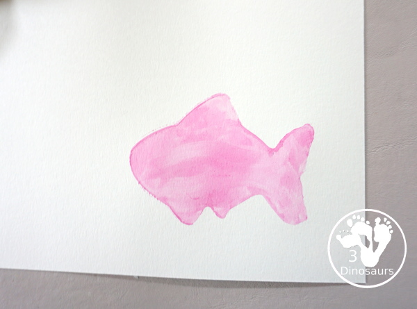 Fish Watercolor Painting with Cookie Cutters is an easy ocean fish painting you can do with kids. You can use one cookie cutter or several fish cookie cutters to make  the painting  - 3Dinosaurs.com