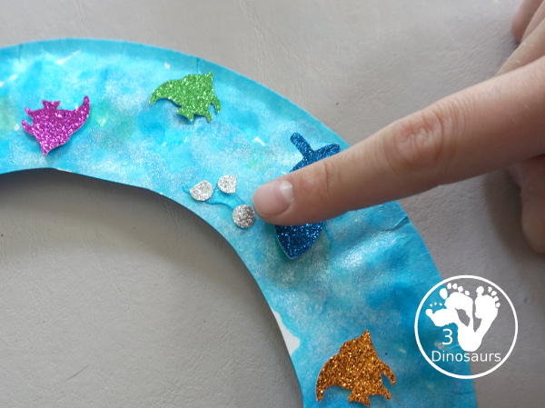 Ocean Wreath with Glitter Fish - A great wreath you can make with an ocean theme. It is a simple and easy-to-make craft for kids of different ages. You have a paper plate, glitter paper, glue and fish punches. - 3Dinosaurs.com