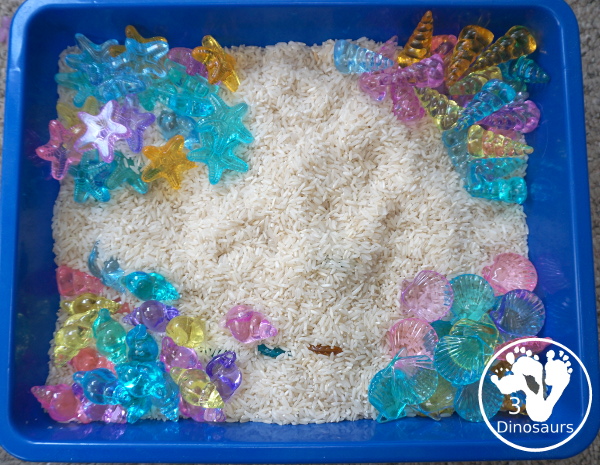 Shell and Rice Sensory Bin has a rice filler with acrylic sheets in different colors as the part in the sensory bin. This is a simple beach sensory bin idea for kids. - 3Dinosaurs.com