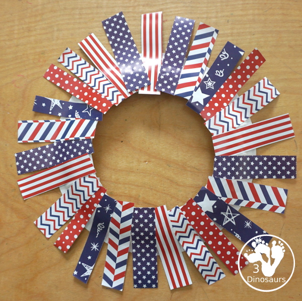 Red White and Blue Wreath Craft - a fun wreath craft made with scrapbook or any type Fourth of July paper with the red and blue themed paper around the paper plate. A simple craft you can do with preschool, prek and kindergarten age kids. - 3Dinosaurs.com
