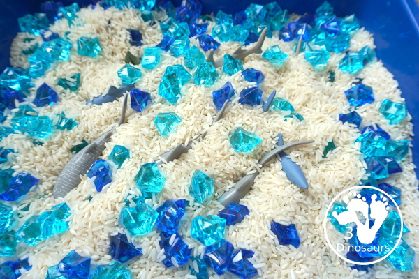 Shark Rice Sensory Bin for shark week with a mix of acrylic rocks, rice and a shark toob for the shark figures for kids to play in prek and kindergarten - 3Dinosaurs.com