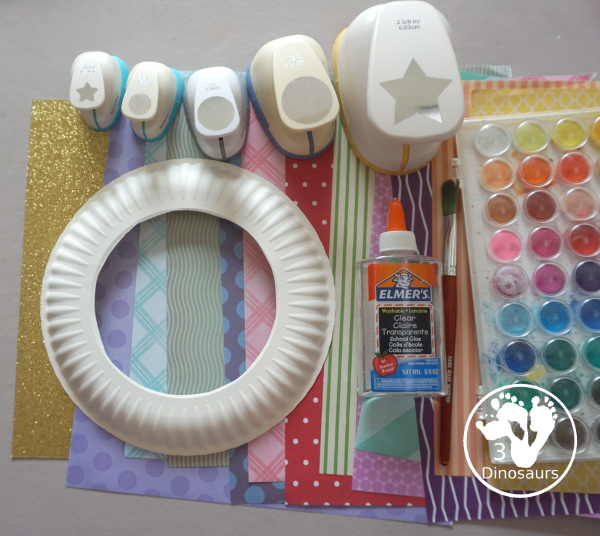 Scrapbook Paper Space Wreath Craft - a fun space craft for kids that is made with a paper plate, craft punches that are circles and stars with glitter paper and scrapbook paper. It makes a fun space craft. - 3Dinosaurs.com