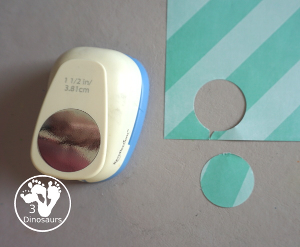 Scrapbook Paper Space Wreath Craft - a fun space craft for kids that is made with a paper plate, craft punches that are circles and stars with glitter paper and scrapbook paper. It makes a fun space craft. - 3Dinosaurs.com