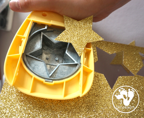 Scrapbook Paper Space Wreath Craft - a fun space craft for kids that is made with a paper plate, craft punches that are circles and stars with glitter paper and scrapbook paper. It makes a fun space craft. - 3Dinosaurs.com