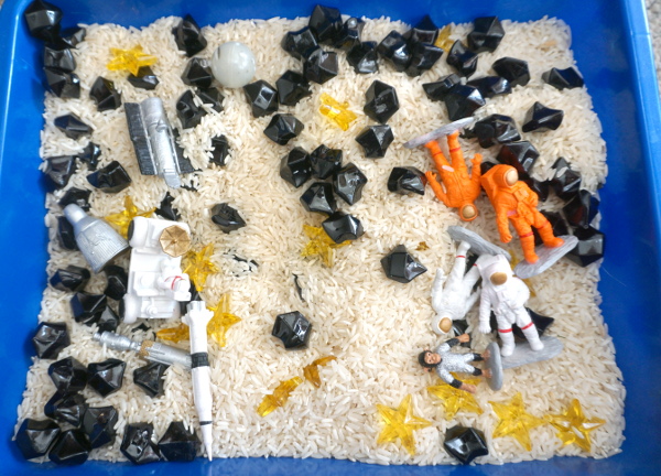 Space Sensory Bin With Rice and Rocks - you have space figures, yellow stars, and rice for this simple sensory b8in. This is great for a space theme with kids. And they will enjoy exploring space themes in the sensory bin. A fun sensory bin for kids in preschool, prek and kindergarten. - 3Dinosaurs.com