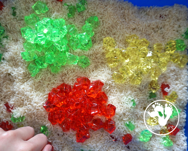 Red, Green and Yellow Sensory Bin - a simple rice and acrylic rock sensory bin with the colors of apples red, green and yellow. A simple time to setup and use. - 3Dinosaurs.com