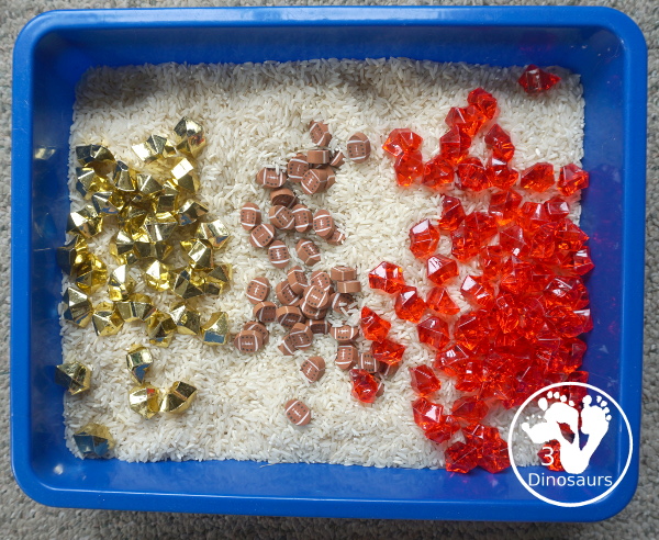 Football Sensory Bin - a simple football sensory bin for kids. You have a mix of green rocks, rice and footballs - 3Dinosaurs.com