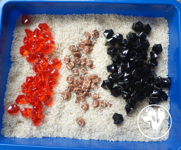 Football Sensory Bin - a simple football sensory bin for kids. You have a mix of green rocks, rice and footballs - 3Dinosaurs.com