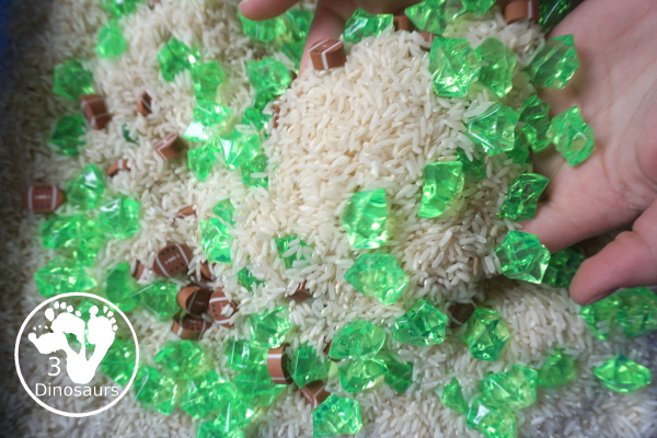 Football Sensory Bin - a simple football sensory bin for kids. You have a mix of green rocks, rice and footballs - 3Dinosaurs.com